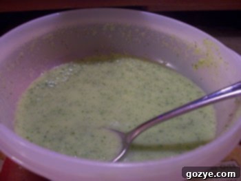 A bowl of creamy Zuke Soup, garnished with fresh herbs.