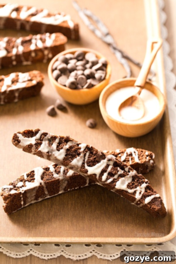 Brownie Biscotti with vanilla glaze cooling on a rack.