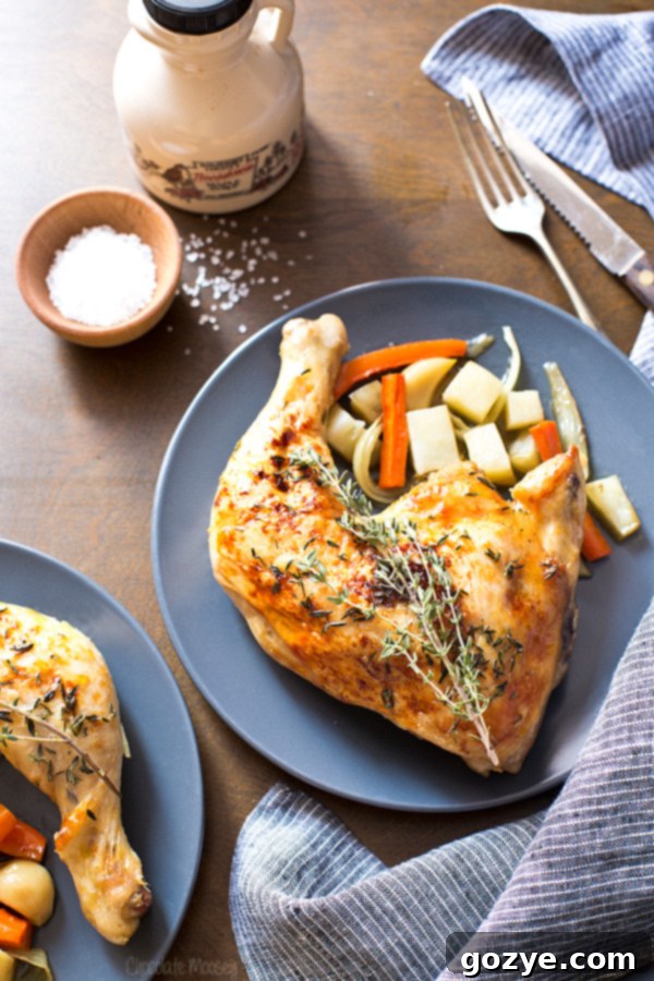 Two plates of roasted chicken quarters with root vegetables and fresh thyme