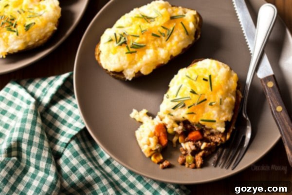 Cottage Pie Baked Potatoes on a plate with a knife and fork, ready to be enjoyed.