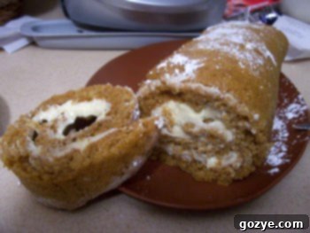 Delicious Pumpkin Roll Cake slice with cream cheese filling