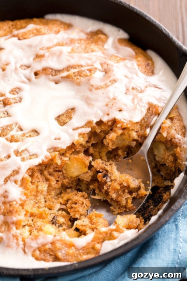 A delectable slice of Carrot Cake Skillet Cake with vanilla glaze, showcasing the moist crumb and wholesome mix-ins.