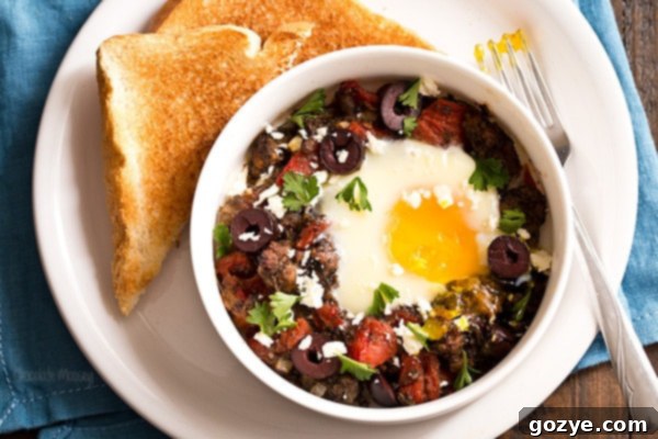 Finished Greek Baked Eggs topped with olives, feta, and parsley