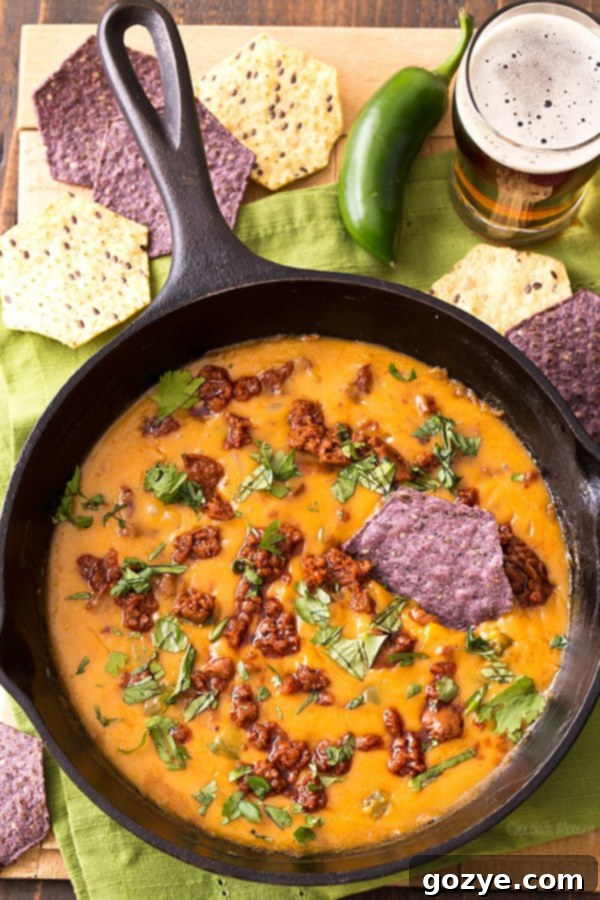 Mexican Beer Cheese Dip with chorizo and jalapeno, served warm with tortilla chips