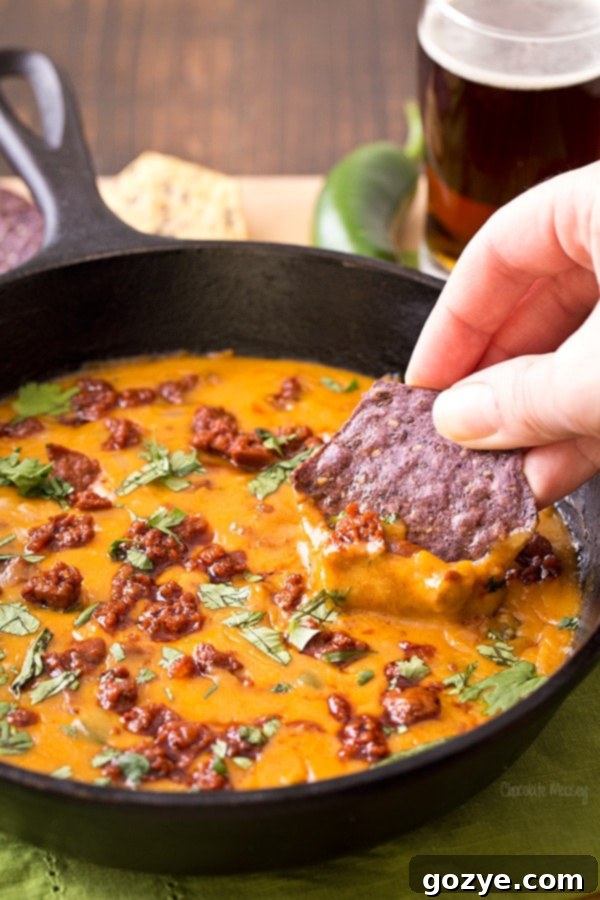 Close-up of Mexican Beer Cheese Dip with chorizo, showing its creamy texture and chunks of sausage