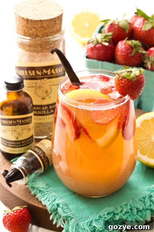 Pitcher of Strawberry Vanilla Sangria with sliced lemons and strawberries.