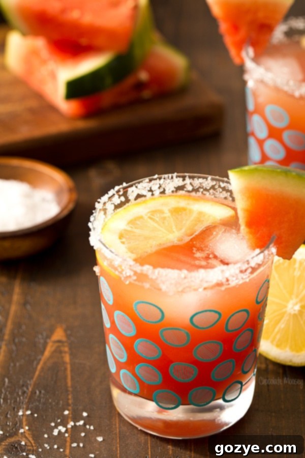 A close-up of a Watermelon Lemonade Margarita with a salt rim and lemon wedge