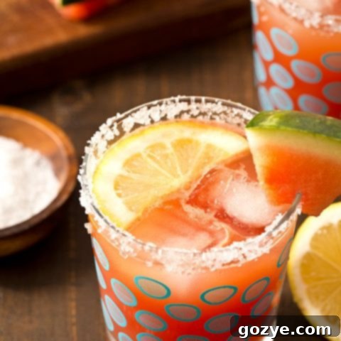 Watermelon Lemonade Margaritas served in two glasses with a pitcher