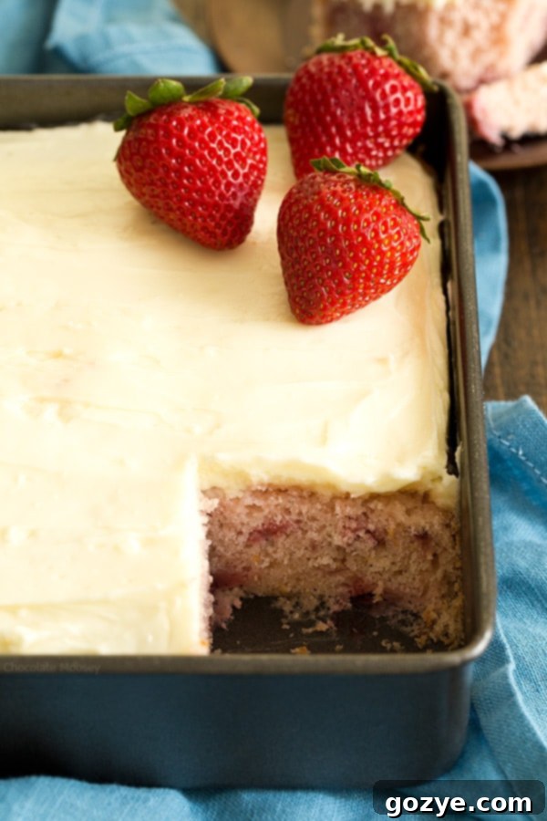 Close up view of Strawberry Snack Cake with a missing slice, showing its moist texture