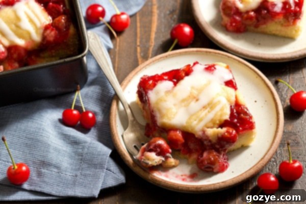 Delectable Cherry Cobbler Bars 5 A serving of Cherry Cobbler Bars, drizzled with a sweet vanilla glaze, ready to be enjoyed as a delightful dessert.