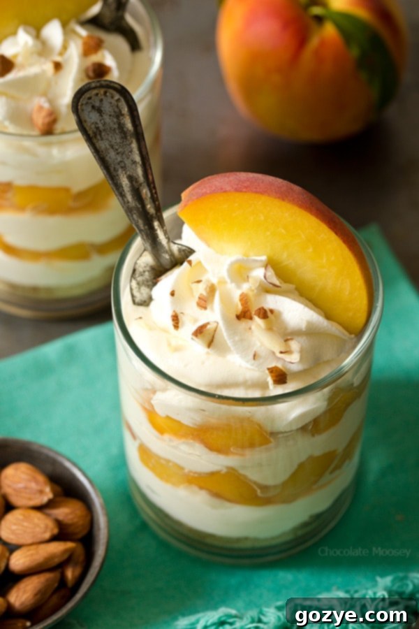 No Bake Peach Cheesecake in parfait glasses, showcasing the completed dessert ready for enjoyment.