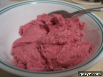 A close-up shot of the perfectly smooth and creamy homemade blackberry sour cream ice cream in a bowl.