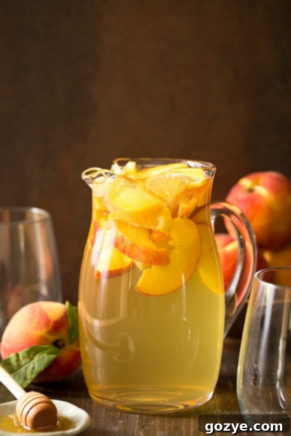 Refreshing Peach Honey Sangria made with white wine, fresh peaches, and a touch of honey, perfect for summer enjoyment.