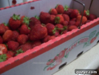 A white bowl filled with sliced fresh strawberries, slightly less full, possibly after some were used, ready for baking.