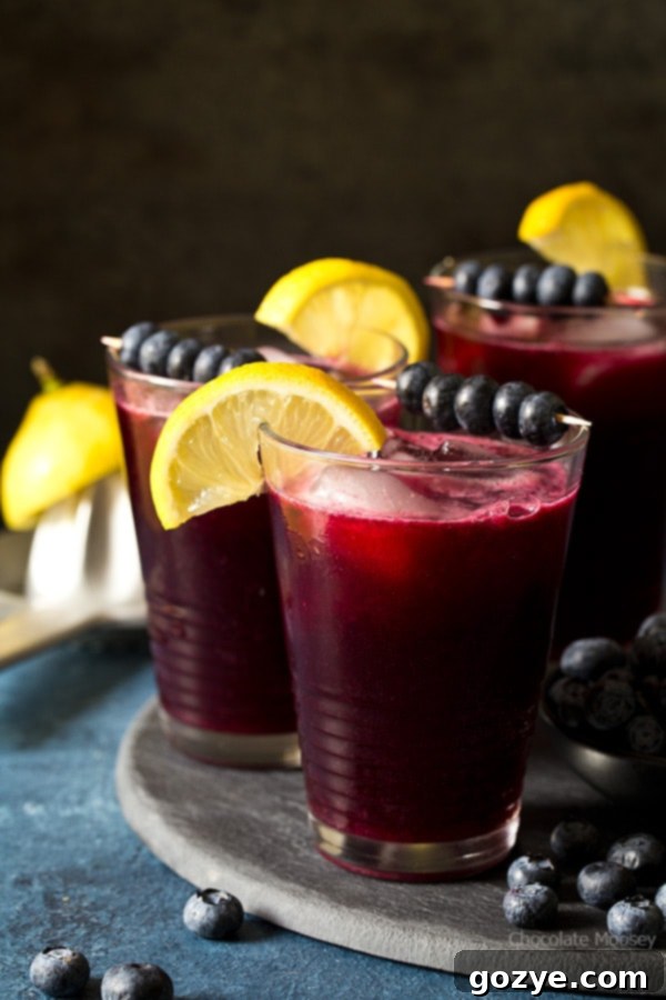 Sparkling Blueberry Lemonade in a glass on a wooden board