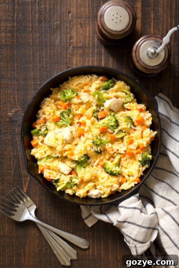 Wide shot of chicken and rice with broccoli in cast iron skillet