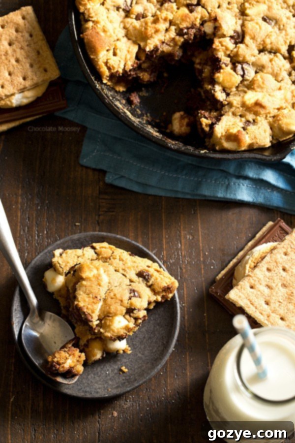 Close-up view of a slice of the gooey skillet cookie, highlighting the pockets of melted marshmallows and chocolate chips.