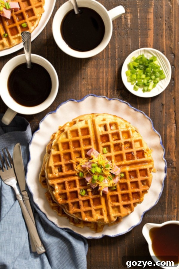 Crispy Ham and Cheese Waffles on a white ruffled plate, garnished with chives, ready to be served