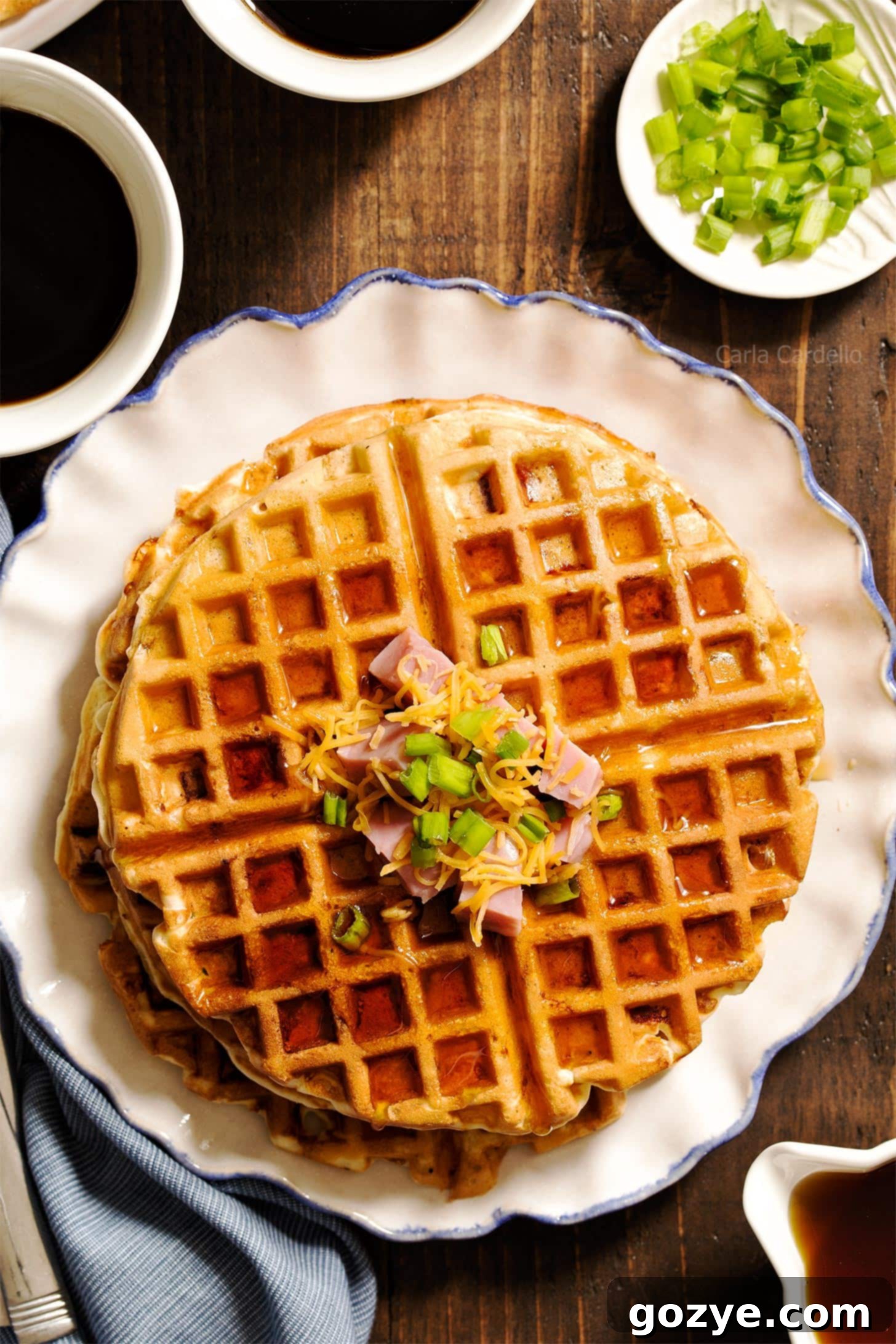 Close up of a stack of fluffy Ham and Cheese Waffles, revealing the cheesy, ham-filled interior