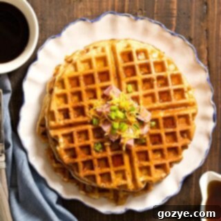 Close up view of golden-brown Ham and Cheese Waffles, ready to eat with a fork