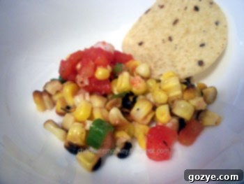Vibrant Grilled Corn on the Cob Salsa in a bowl, with fresh ingredients like tomatoes and scallions in the background.