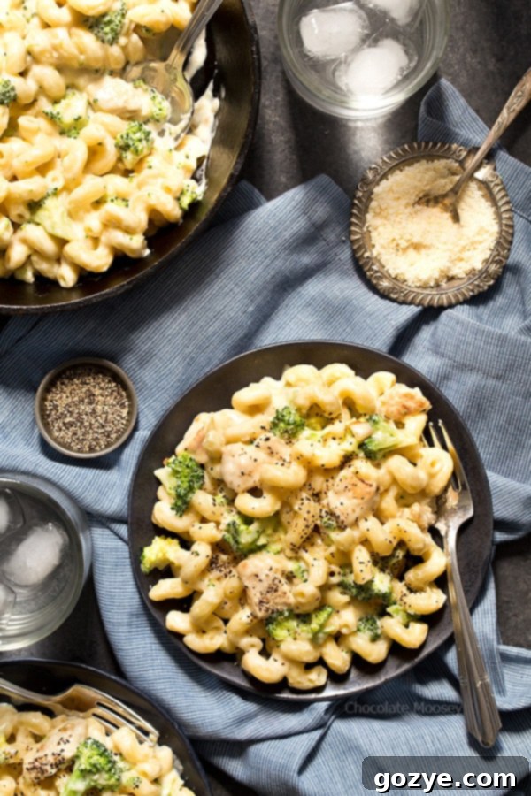The Ultimate Alfredo Mac and Cheese 3 Alfredo mac and cheese on black plate with fork, garnished with fresh parsley