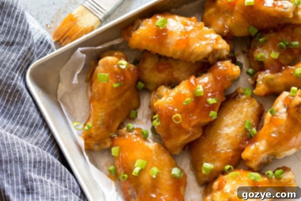 Crispy chicken wings baking on a wire rack in the oven, golden brown and ready for sauce