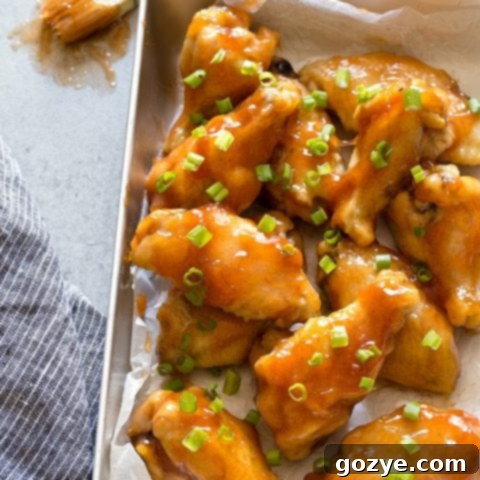 Sweet and Sour Chicken Wings on a plate with green onion garnish