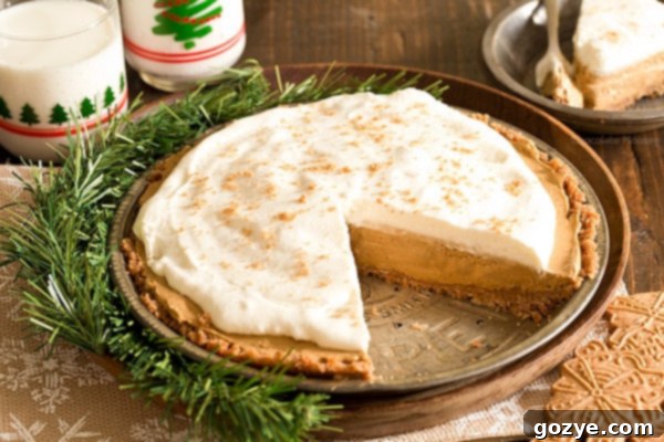 A close-up view of a slice of No Bake Gingerbread Pie, showcasing the distinct layers of the speculoos crust and the creamy, spiced gingerbread filling.