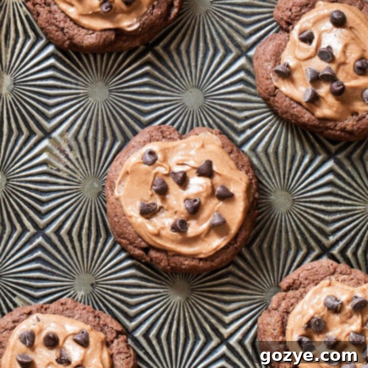 Close up of chocolate sugar cookie recipe on tray, showing soft centers and rich frosting