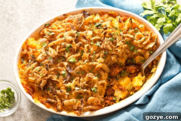 Recipe for chorizo and potatoes in white casserole dish with fresh cilantro garnish