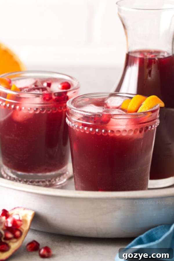 Pomegranate Punch in elegant glasses on a silver tray, ready to serve at a festive gathering