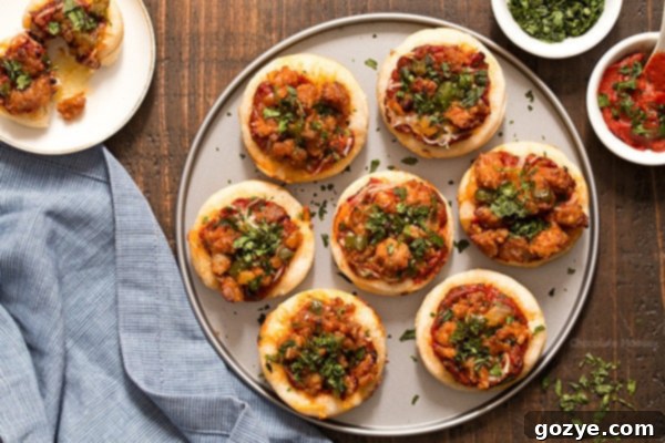 A close-up view of the raw Italian Sausage Pizza Bites in a muffin pan before baking, showing the sauce, cheese, and sausage topping