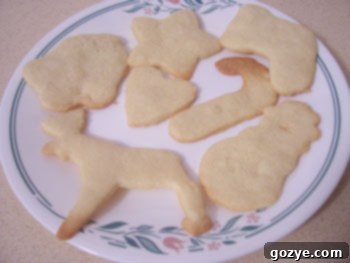 A batch of plain, undecorated sugar cookies fresh out of the oven, piled on a plate.