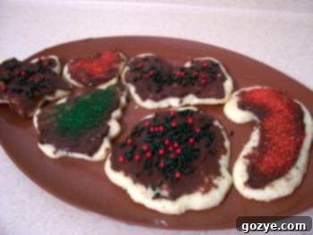 A collection of holiday-themed sugar cookies, some decorated with sprinkles, others with simple icing patterns.