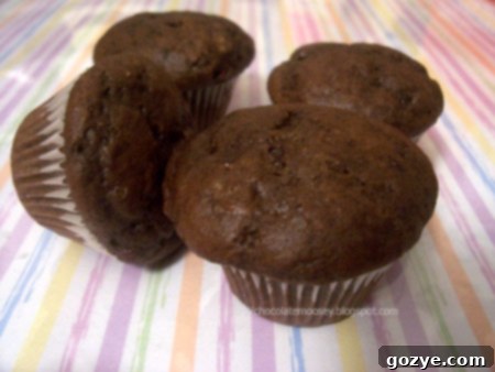 A close-up view of a perfectly baked mini chocolate chunk muffin, showing its rich texture and melty chocolate pieces.