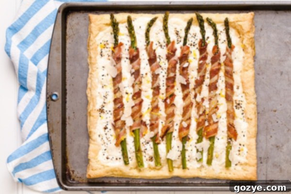 Flaky Asparagus and Bacon Puff Tart 3 Close-up of a perfectly baked Bacon Wrapped Asparagus Puff Pastry Tart with a creamy ricotta base.