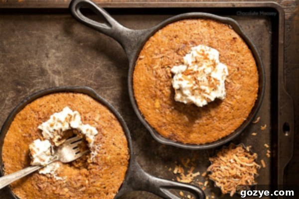 A close-up of a Toasted Coconut Skillet Cake, showing its beautifully golden-brown crust and moist interior, ready to be enjoyed. The toasted coconut flakes are visible on top, adding texture and aroma.