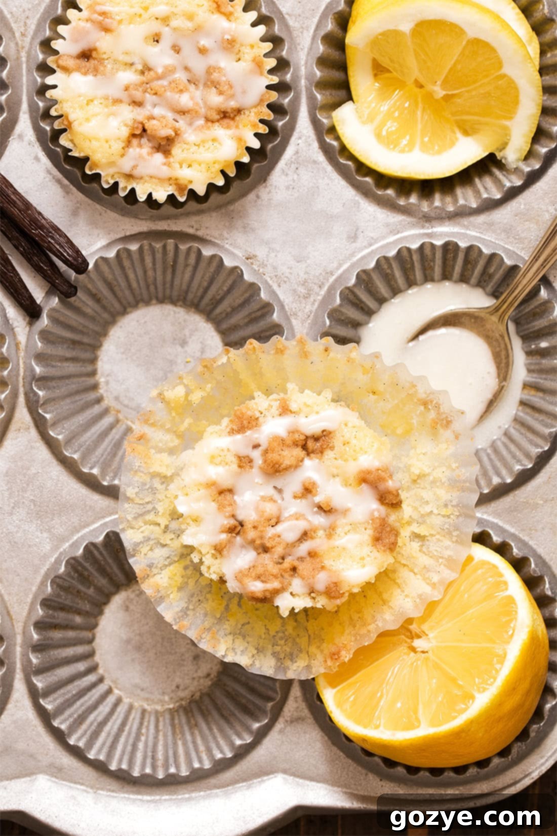 Unwrapped lemon crumble muffin with muffin pan