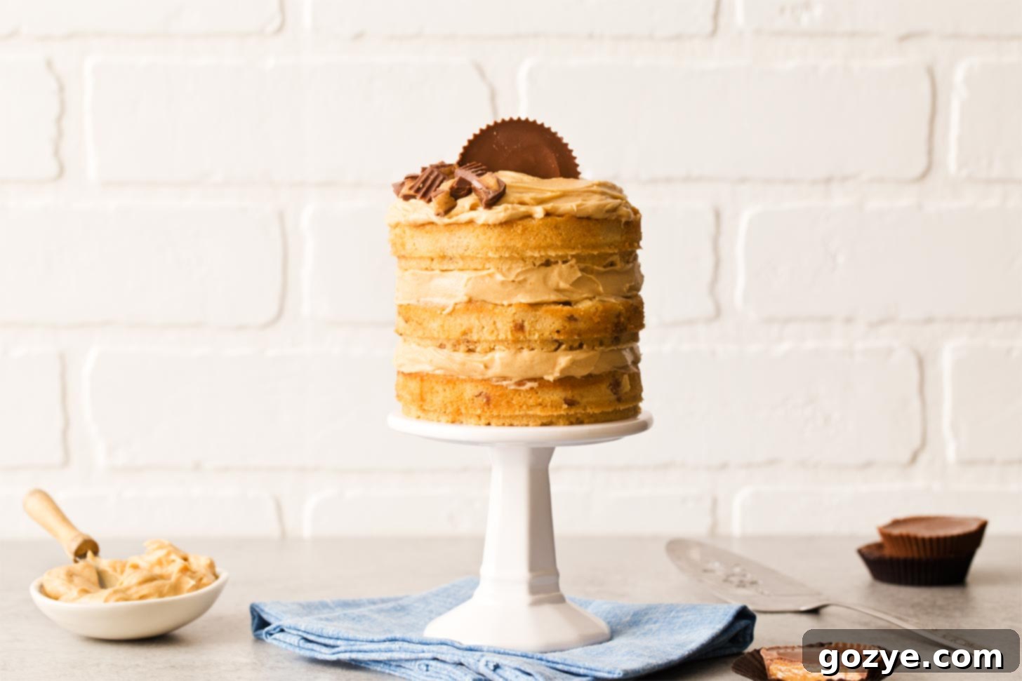 Peanut butter layer cake on a mini cake stand, beautifully frosted