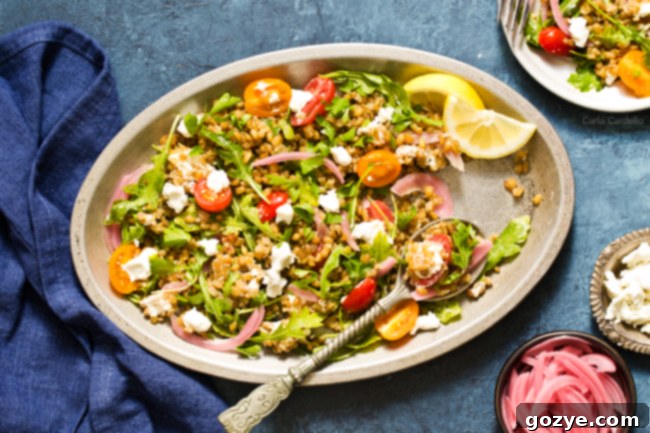 A close-up shot of the vibrant Freekeh Salad, showcasing the texture of the grain, fresh arugula, and colorful additions.