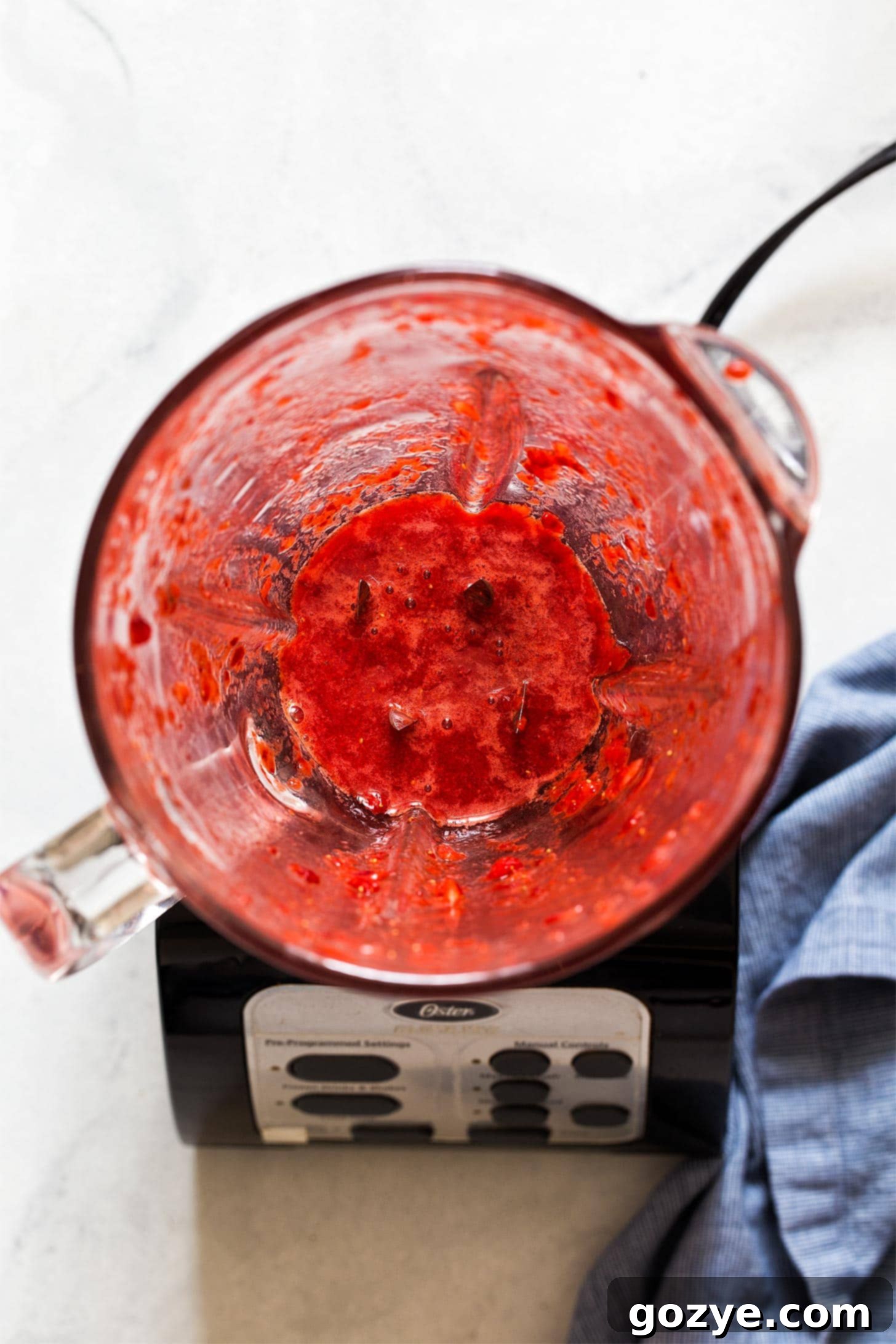 Blending fresh strawberries and sugar for strawberry cream cheese frosting