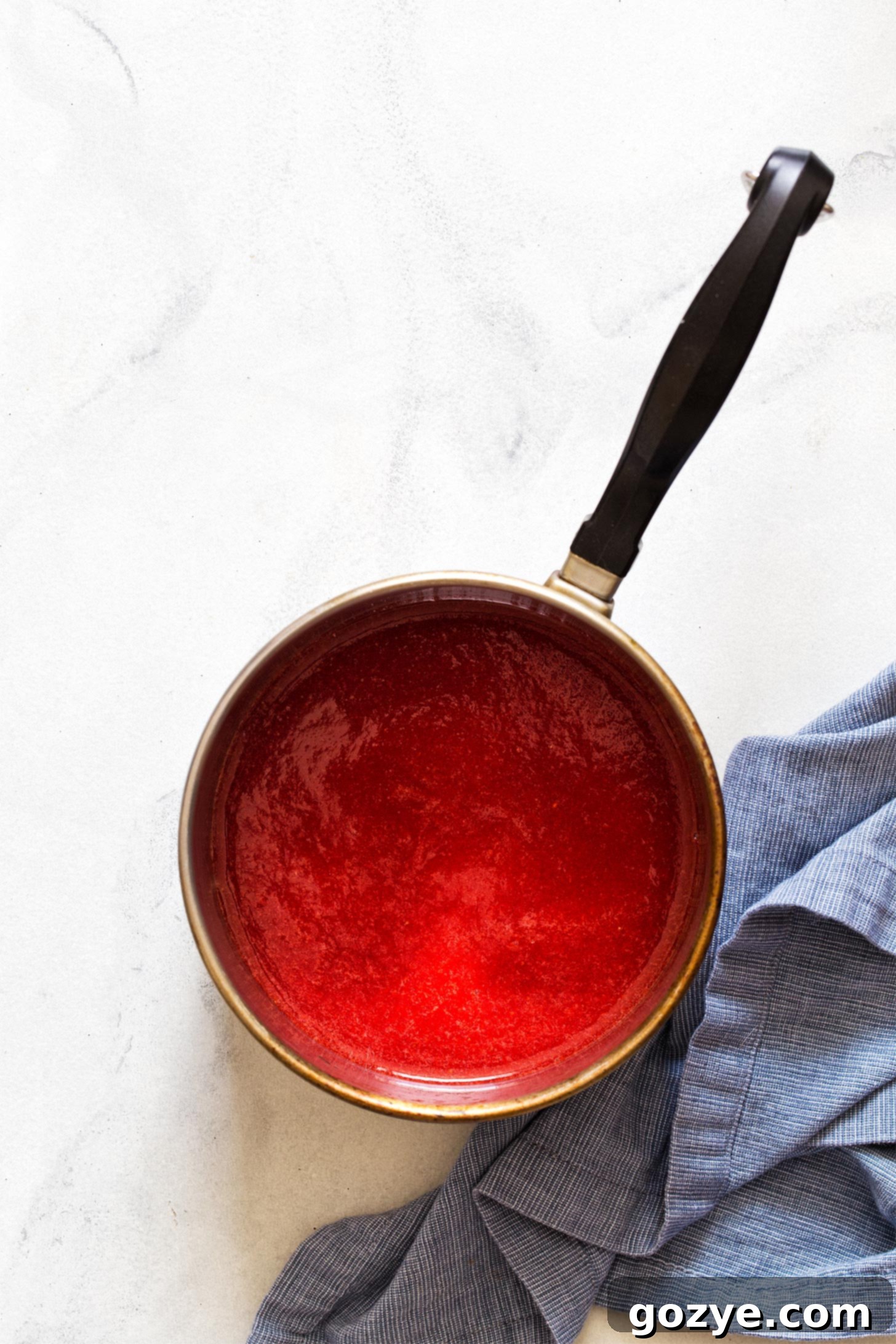 Cooking strawberry puree in a saucepan for frosting