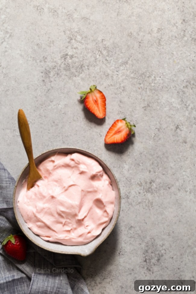 Bowl of naturally pink strawberry cream cheese frosting