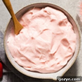 Close up of a bowl of creamy, pink Strawberry Cream Cheese Frosting