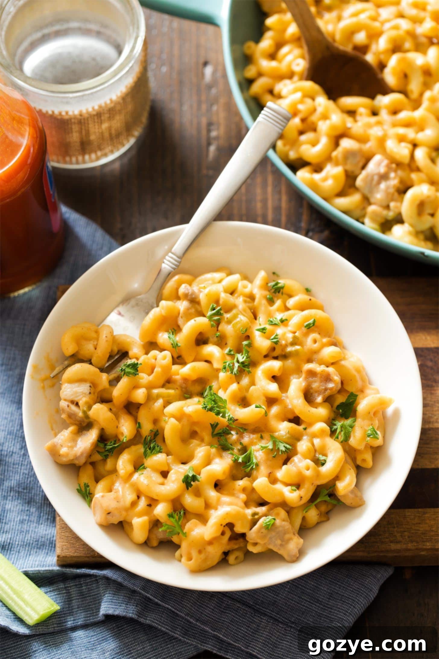 White bowl filled with buffalo chicken mac and cheese with fork