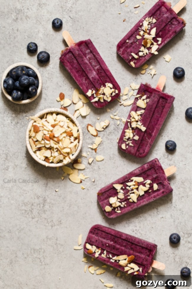 Vibrant Blueberry Yogurt Popsicles with crunchy almonds, perfect for summer.