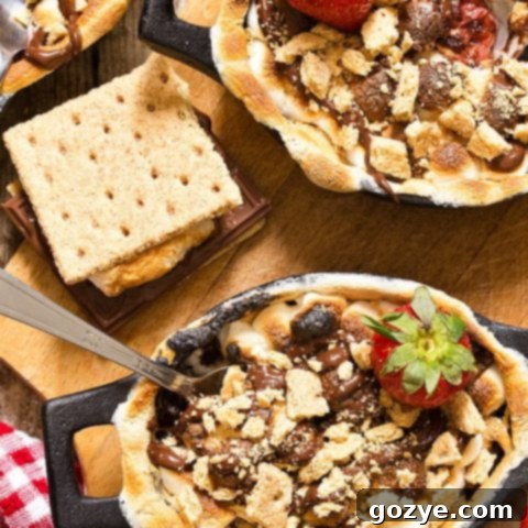 Irresistible Strawberry S’mores Cobbler featuring a gooey chocolate strawberry base, topped with perfectly toasted marshmallows and graham crackers.