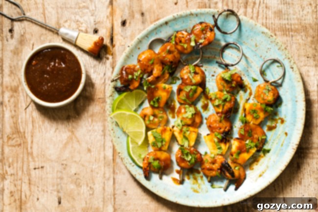 A serving of Grilled Pineapple Shrimp Teriyaki Kabobs alongside a bed of white rice, garnished with fresh cilantro.