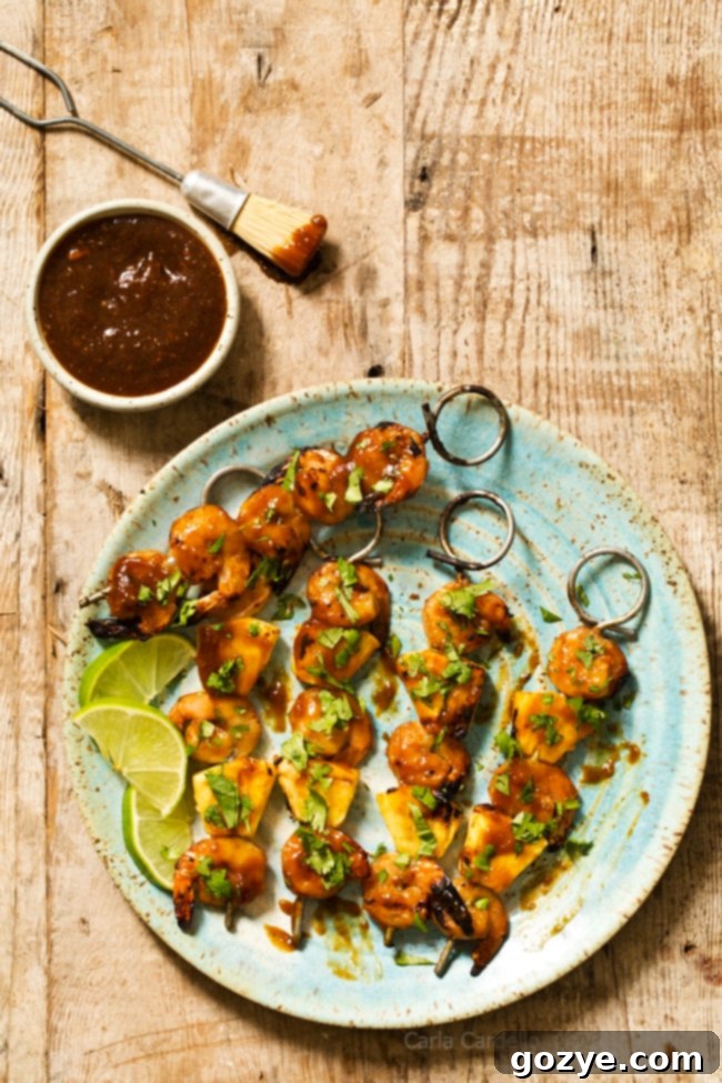 A spread of four Grilled Pineapple Shrimp Teriyaki Kabobs, garnished with fresh herbs and ready to be enjoyed.